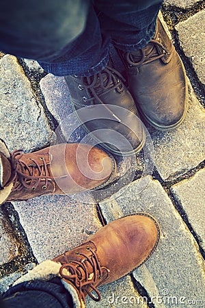 Relationship in a pair of lovers, two side by side. feet in shoes on the paving slabs. Stock Photo