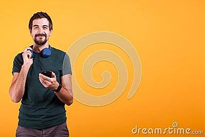 Relax attractive man with blue headphones and smartphone in his hands Stock Photo