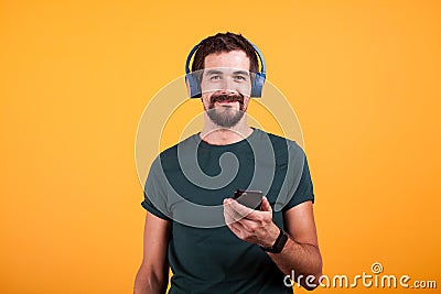 Relax attractive man with blue headphones and smartphone in his hands Stock Photo
