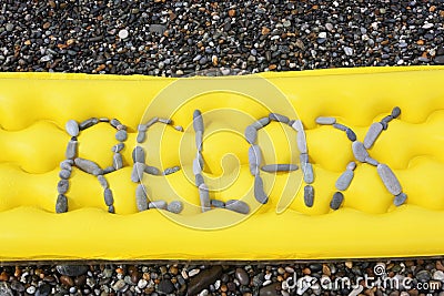 Relax message from pebbles on a air-bed. Stock Photo