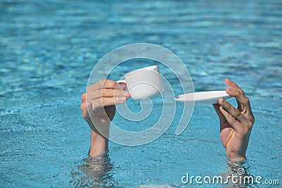 Relax in water - hands above water holding cup and small plate Stock Photo