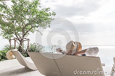 Relaxation holiday vacation of businessman take it easy happily resting on beach chair at swimming pool poolside beachfront resort Stock Photo