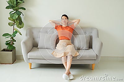 Relaxed calm woman resting breathing fresh air feeling mental balance enjoying wellbeing at home on sofa Stock Photo