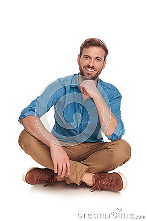 Relaxed casual man is smiling and sitting down Stock Photo