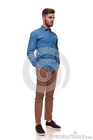 Relaxed casual man standing looks to side Stock Photo