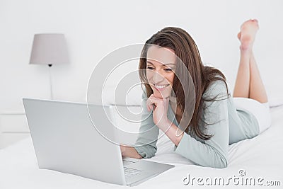 Relaxed casual smiling woman using laptop in bed Stock Photo