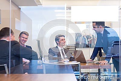 Relaxed cheerful business people sitting and talking at corporate meeting. Stock Photo