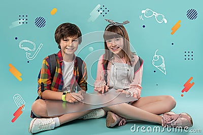 Relaxed children smiling and sitting with a transparent device Stock Photo