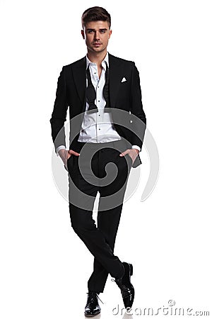 Relaxed elegant man with undone bowtie standing cross-legged Stock Photo