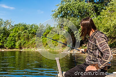 Relaxed fishing from boat in shallow water Stock Photo