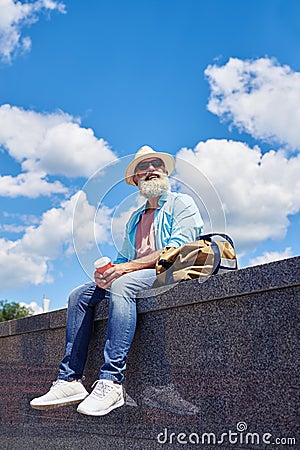 Relaxed guy aged of 50-60 enjoying city while drinking coffee Stock Photo