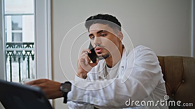 Relaxed guy calling cellphone at home closeup. Serious man drinking cola at home Stock Photo