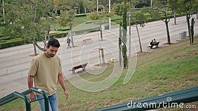 Relaxed guy going upstairs city park at summer weekend. Italian man walking up Stock Photo