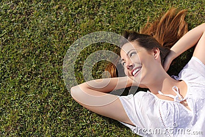 Relaxed happy woman resting on the grass looking at side Stock Photo