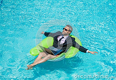 relaxed man trader work and relax. man trader work and relax in swimming pool. Stock Photo