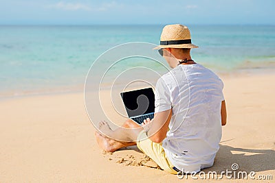 Relaxed man working with laptop on the beach Stock Photo
