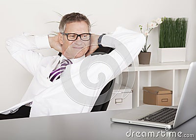 Relaxed Physician Smiling While Watching at Laptop Stock Photo