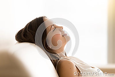 Relaxed teen girl dreams with closed eyes on sofa Stock Photo