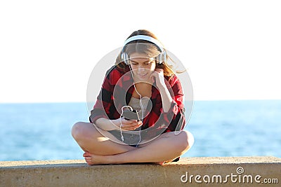 Relaxed teen is listening to music on the beach Stock Photo