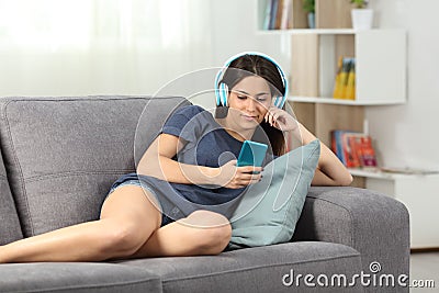 Relaxed teen listening to music lying on a couch Stock Photo