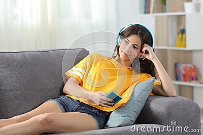 Relaxed teen listening to music on a couch Stock Photo