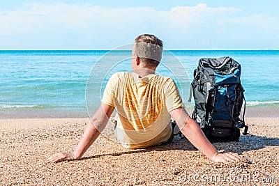 Relaxed tourist with a backpack near the sea Stock Photo