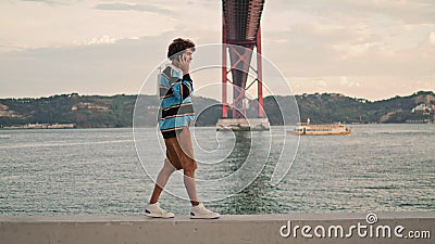 Relaxed tourist speaking smartphone Lisbon embankment. Curly guy talking mobile Stock Photo