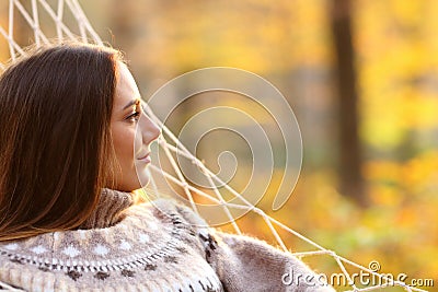 Relaxed woman contemplating on hammock in autumn Stock Photo