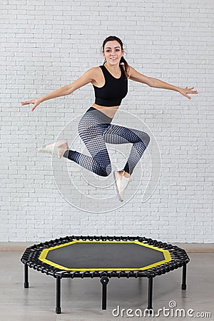 Relaxed woman jumping on trampoline. Stock Photo