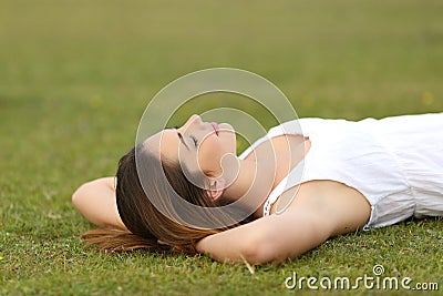Relaxed woman lying on the grass sleeping in a tranquil scene Stock Photo