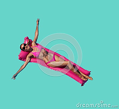 Relaxed woman pink on inflatable matrass over blue Stock Photo