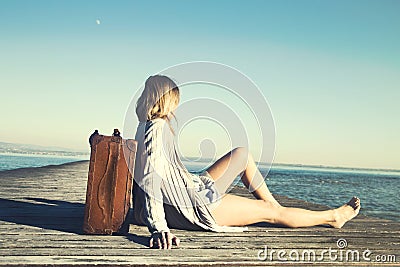 Relaxed woman resting after a long journey with her big suitcase Stock Photo