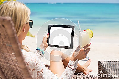 Relaxed woman using tablet computer on the beach Stock Photo