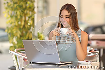 Relaxed woman watching a laptop in a restaurant Stock Photo