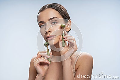 Relaxed young woman doing a facial massage Stock Photo