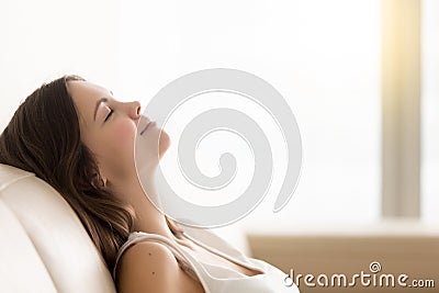 Relaxed young woman enjoying rest on comfortable sofa, copy spac Stock Photo