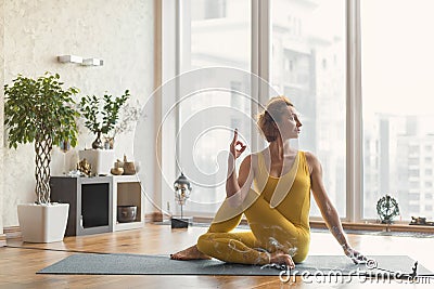 Relaxed young woman meditating at home Stock Photo