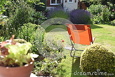 Relaxing area in garden with a deck chair on the lawn during a sunny day Stock Photo