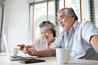 Relaxing Asian Senior couple making video call and talking with family on Laptop computer. Happy Smiling Japanese Elderly man and Stock Photo