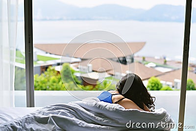 Relaxing in bed, Woman traveler laying down resting at poolside on lazy sunday at the hotel. Stock Photo