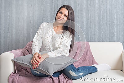 Relaxing at home, comfort. cute young woman smiling, relaxing on white couch, sofa at home Stock Photo