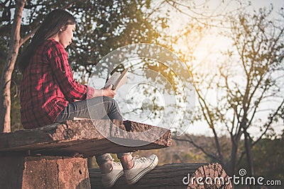 Relaxing moment Asian tourist reading a book on park Stock Photo