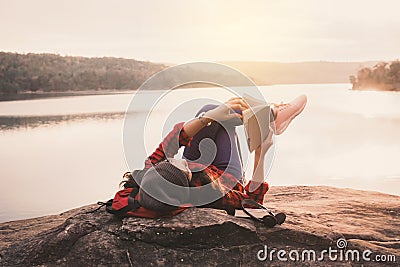 Relaxing moment Asian tourist reading a book on rock Stock Photo