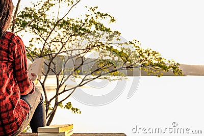 Relaxing moments, Young woman reading a book in nature background. Solo relaxation, color of Hipster Tone. Stock Photo