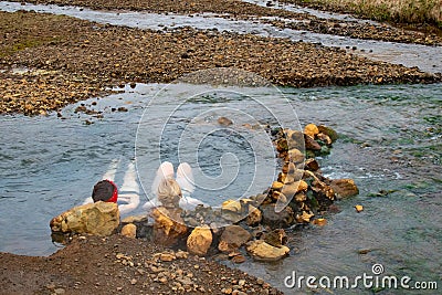 Relaxing Soak in Nature: Two Women Enjoying Reykjadalur Hot Spring Thermal River, Iceland Stock Photo