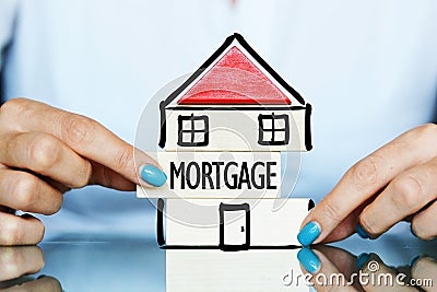 Release the mortgage of the property concept with young woman and house symbol on a table Stock Photo