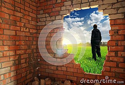 Release to freedom. Man, standing behind broken brick wall Stock Photo