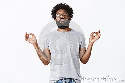 Releasing pressure with meditation. Portrait of calm and peaceful adult african american bearded man with tattoos and Stock Photo