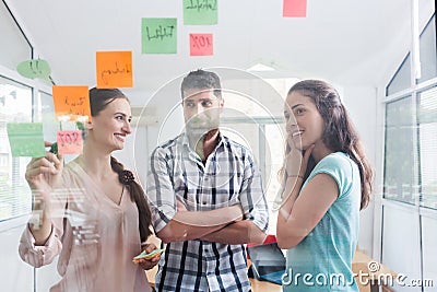 Reliable young workers posting reminders in a modern co-working space Stock Photo