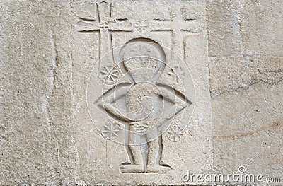 Relief with christian crosses and alien like person on wall of the 4th century Samtavro Church in Mtskheta, Georgia. Stock Photo